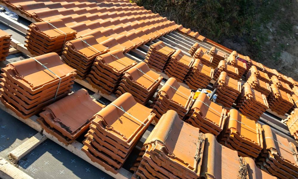 stacks-of-yellow-ceramic-roofing-tiles-for-covering-residential-building-roof-under-construction-q0guzuvcg13jpaxq95zeglqlgeqbsvd4fi7p5goay8